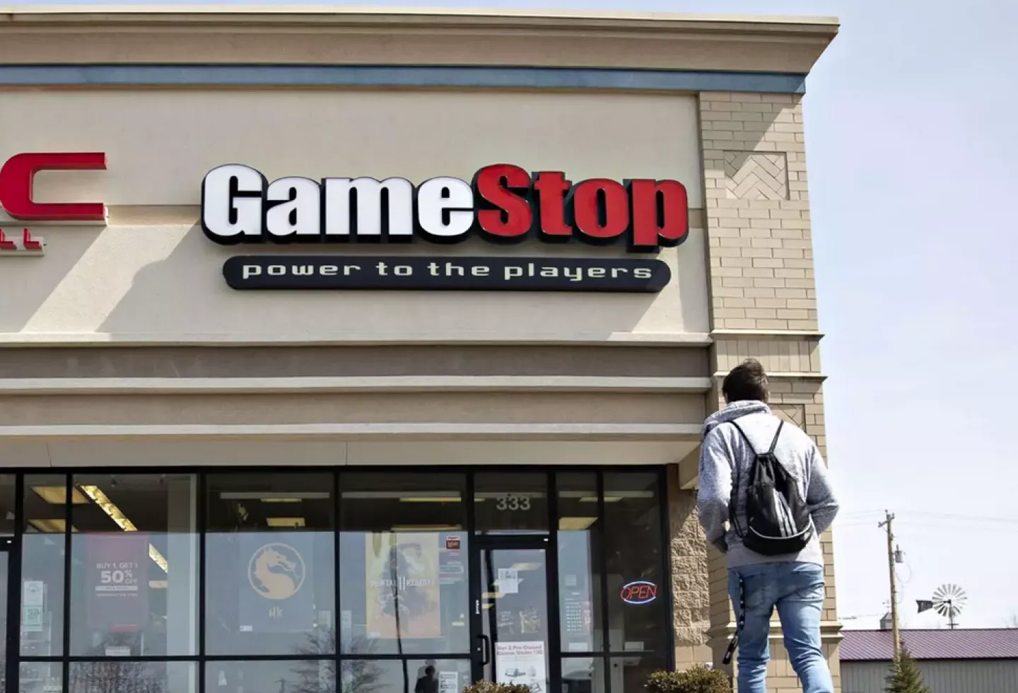 Image: Person standing outside gamestop shop for Gamestop Shareholder Meeting
