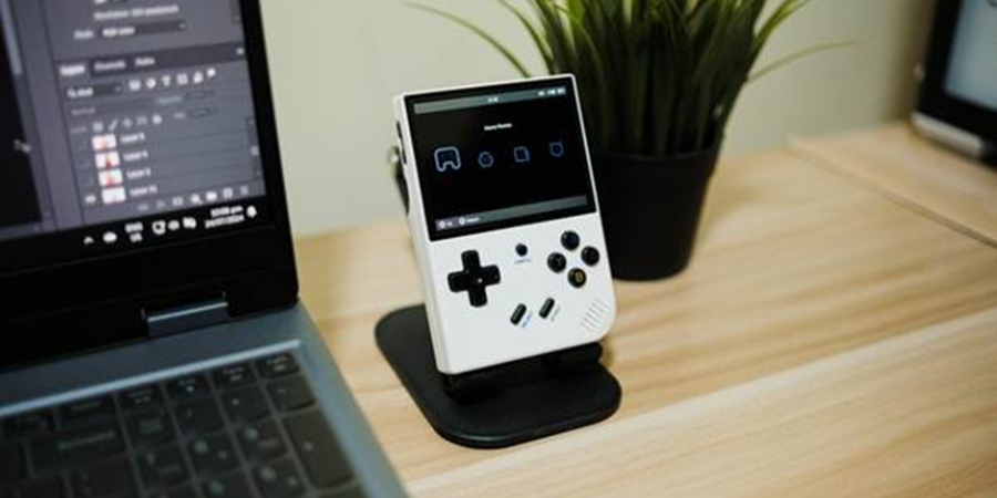 Retro gaming device beside laptop